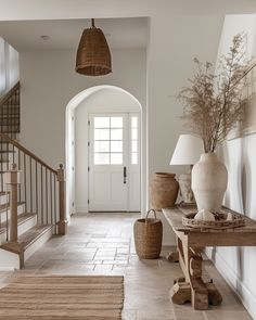 an entry way with vases and lamps on either side of the entranceway,