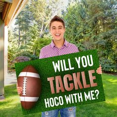 a man holding a sign that says will you tackle hoco with me?