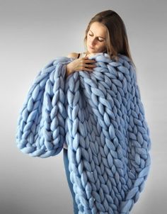 a woman wrapped in a giant chunky blanket