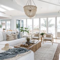 a living room filled with furniture and a chandelier hanging over the top of it