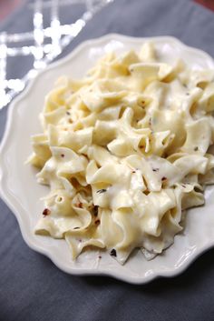 a white plate topped with macaroni and cheese on top of a blue table cloth