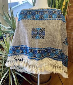 These beautiful ponchos are handmade by indigenous artisans in Hueyapan Puebla. Every design is unique, hand-embroidered according to the traditions of the community. Measuring approximately 34" wide by 26'' long, one size should fit all adults. All ponchos can be worn 2 ways: Flat across the front or point down, for a longer, more flowing look. Mexican Gifts, Mexican Outfit, Tropical Decor, Simply Beautiful, The Community, Handmade Art, Hand Embroidered, Hand Embroidery, Blue Grey