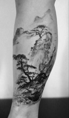 a black and white photo of a person's leg with trees on it