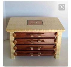 a wooden table with three drawers and a clock on the top one drawer is made out of wood