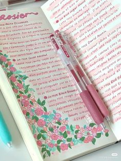 a pink pen sitting on top of an open notebook