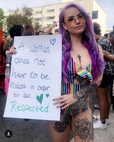 a woman holding a sign that says, a woman does not have to be modest in order to be respected