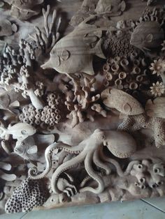 an intricately carved wood panel with sea creatures and corals