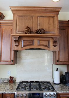 a stove top oven sitting inside of a kitchen next to wooden cupboards and counter tops