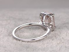 a close up view of a diamond ring on a white surface with the center stone missing