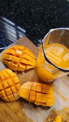 sliced mangoes on a cutting board next to a glass of orange juice