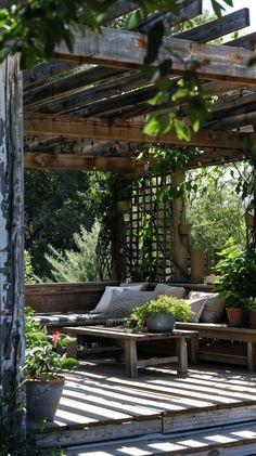 an outdoor seating area with potted plants on the side and wooden pergoline