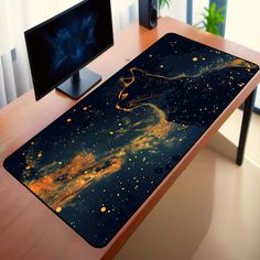 a computer desk with two monitors and a mouse pad on it that has gold stars in the sky