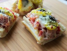 four sandwiches with different toppings are on a cutting board