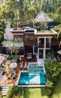 an aerial view of a house with a pool in the yard and trees surrounding it