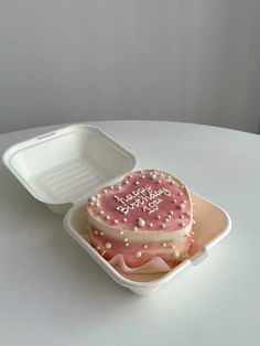 a heart shaped cake in a plastic container on a white table with the lid open