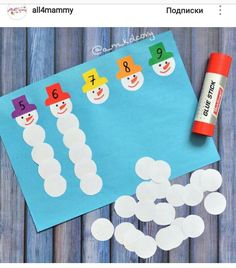 the snowman counting game is next to a roll of paper and some glue stick