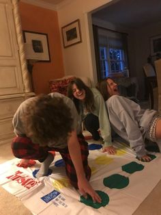 three people are doing crafts on the floor