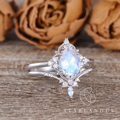 an engagement ring with a pear shaped white topazte surrounded by small diamond accents