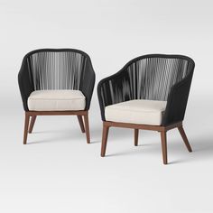 two black chairs with white cushions and wooden legs, one in the shape of a chair