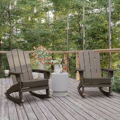 two rocking chairs sitting on top of a wooden deck