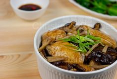 a bowl filled with meat and vegetables on top of a wooden table