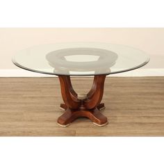 a glass table with wooden legs and a circular base in the center on a hard wood floor