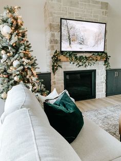 a living room with a christmas tree and a flat screen tv mounted on the wall