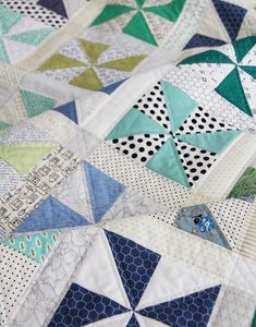 a close up view of a quilt with many different colors and shapes on the fabric