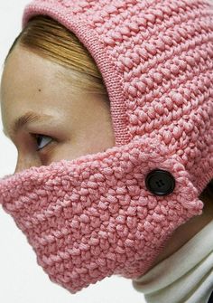 a woman wearing a pink knitted hat with buttons