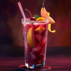 a glass filled with liquid and fruit on top of a table