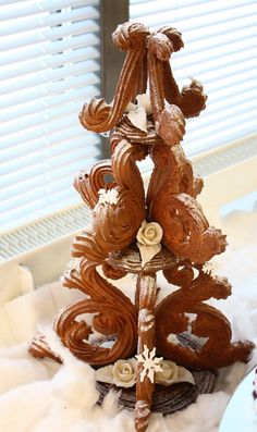 a small christmas tree made out of bread and icing on top of a table