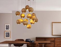 a dining room table and chairs with lights hanging from the ceiling