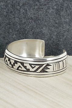 This sterling silver bracelet featuring a traditional Navajo pattern was made by Navajo silversmith Rosita Singer. The back is signed T&R Singer and stamped sterling.Size: 5 1/2" (will fit a 6 3/4" wrist)Gap: 1 1/4"Length: 3/4"Free shipping on all orders! We ship with USPS and always include tracking. All orders ship within a day of payment.Returns are accepted up to 30 days after you receive your order. Just send us a message. Our shop offers cash back or store credit. The item must be returned Etched Sterling Silver Bracelet In Traditional Style, Adjustable Silver Southwestern Bangle, Traditional Etched Sterling Silver Bracelet, Adjustable Southwestern Silver Bangle, Artisan Sterling Silver Bracelet With Etched Details, Artisan Sterling Silver Bracelet With Inlay, Adjustable Etched Sterling Silver Southwestern Bracelet, Adjustable Etched Southwestern Sterling Silver Bracelet, Traditional Sterling Silver Etched Cuff Bracelet