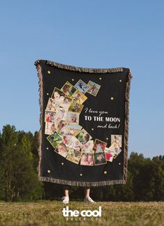 a woman standing in front of a black blanket with pictures on it and the words i love you to the moon