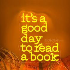 a neon sign that says it's a good day to read a book on the wall