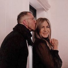 an older man and woman kissing each other in front of a mirror with their faces close together