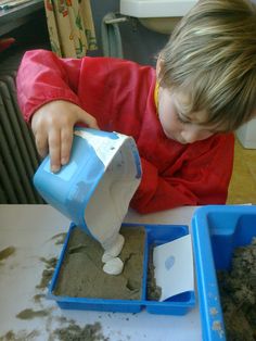 a young boy playing with sand and water