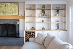 a living room filled with furniture and a fire place in front of a book shelf