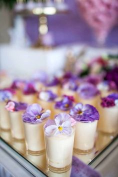 small glasses filled with purple and white flowers