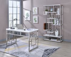 a white desk sitting in front of a window next to a book shelf filled with books