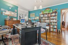 a home office with blue walls and wooden floors