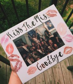 someone holding up a photo frame with lipstick on it that says kiss the miss goodbye