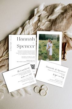 the wedding stationery is laid out on top of some feathers