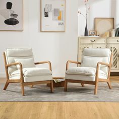 two white chairs sitting next to each other on a wooden floor in a living room