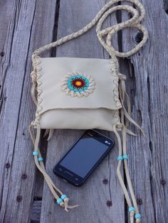 A beaded crossbody handbag done in soft palomino leather. This small leather pouch has a beaded sunflower focal point on the front of the bag. The measurements are 6 inches tall x 5.5 inches wide. The shoulder strap is 48 inches . If you would like a different shoulder strap length please leave us a note at checkout or contact us. Let us know if you would prefer a different color of leather. We have a color chart in the last picture. This leather handbag is hand stitched. We decorated this bag w Everyday Beaded Crossbody Shoulder Bag, Bohemian Handheld Beaded Shoulder Bag, Bohemian Beaded Crossbody Shoulder Bag, Beaded Purse Native American, Beaded Sunflower, Small Leather Pouch, Leather Phone Bag, Beaded Crossbody Bag, Leather Medicine Bag