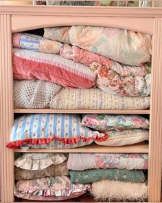 an old dresser is filled with pillows and blankets