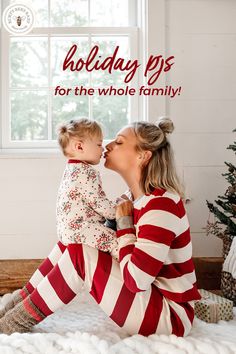 a woman holding a baby in her arms while sitting on a bed with the words holiday pjs for the whole family