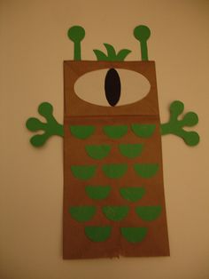 a brown paper bag with green leaves on it and an eye in the center, made to look like a monster