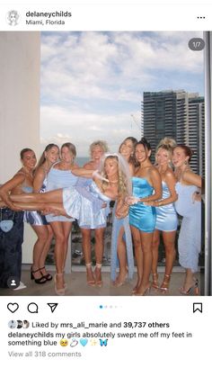 a group of women standing next to each other in front of a building with tall buildings