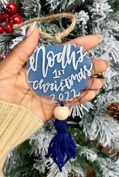 a hand holding a glass ornament with the words merry christmas written on it